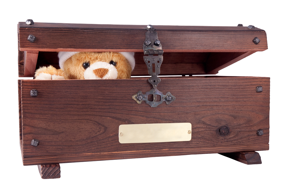 Teddy bear poking its head out of a wooden box