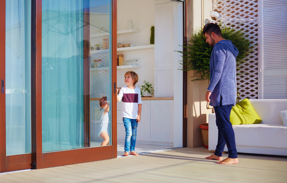 A father helping his children outside of wooden sliding doors