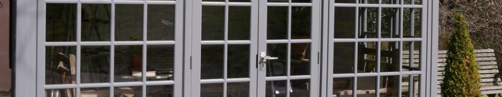 A wooden conservatory painted in grey