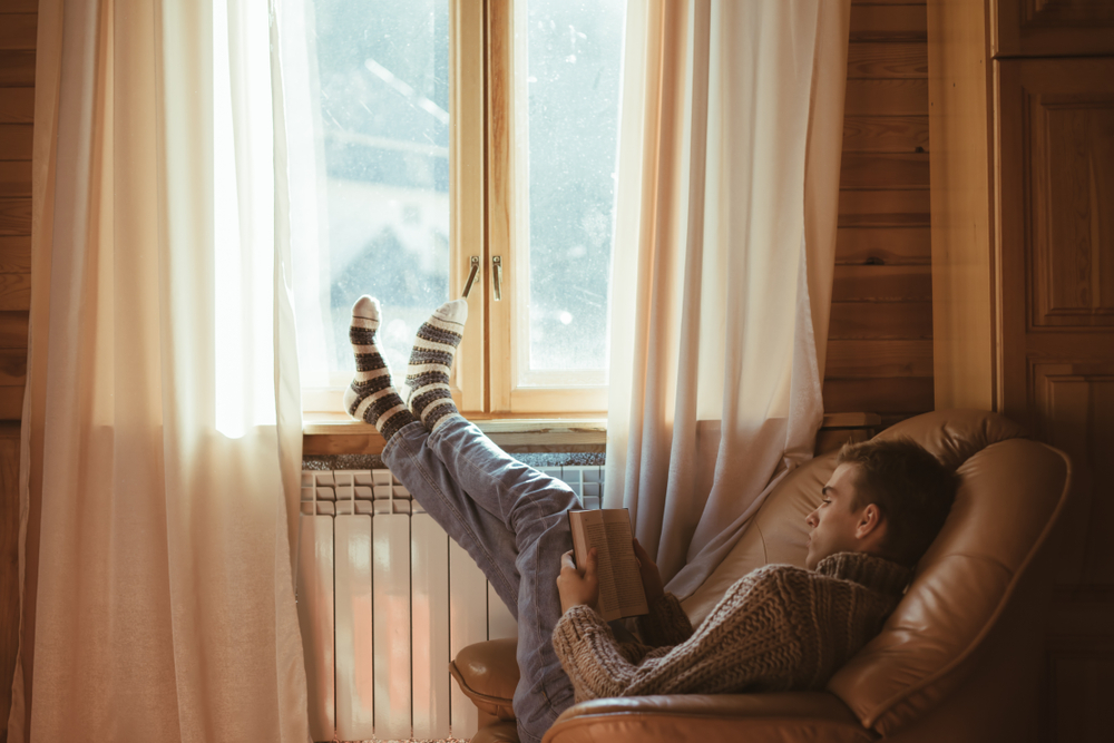 A man warm and comfortable with his feet up in his bespoke joinery home.